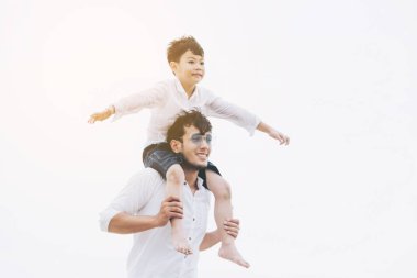 Mutlu baba oğlu yaz aylarında boyun tropikal bir kum Plajı üzerinde taşıyan.