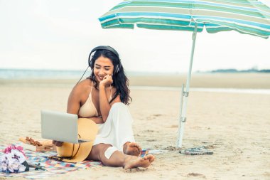 Artı boyutu yaz aylarında tropikal Kum Plajı üzerinde oturan bir genç bayan. Tatil seyahat etmek tatil.