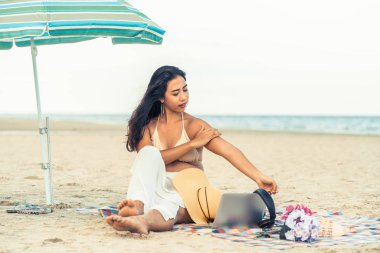 Artı boyutu yaz aylarında tropikal Kum Plajı üzerinde oturan bir genç bayan. Tatil seyahat etmek tatil.