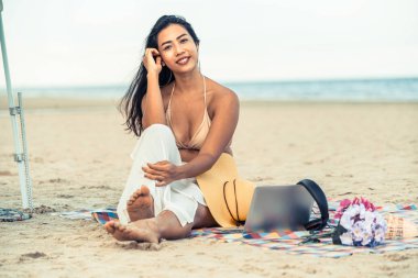 Artı boyutu yaz aylarında tropikal Kum Plajı üzerinde oturan bir genç bayan. Tatil seyahat etmek tatil.