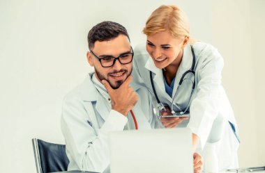 Doktor hastane ofis dizüstü bilgisayar masanın üzerinde başka bir doktor hasta sağlık hakkında tartışma ile çalışma.