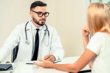 Erkek doktor hastane ofiste bayan hasta konuşuyor. Sağlık ve tıbbi hizmet.