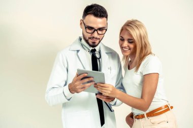 Erkek doktor ve Bayan hasta sağlık veri kaydı için tablet bilgisayar bakıyor. Sağlık ve tıbbi hizmet.