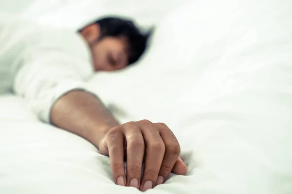 年轻男子睡在白色亚麻床在卧室 — 图库照片