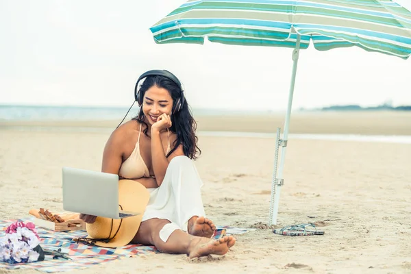 Artı boyutu yaz aylarında tropikal Kum Plajı üzerinde oturan bir genç bayan. Tatil seyahat etmek tatil.