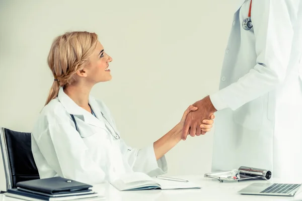 成功と医療スタッフのチームワークを示す別の医者に握手を与える病院医師 — ストック写真