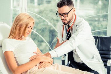 Erkek doktor konuşuyor ve Bayan hasta hastane ofisinde inceleyerek. Sağlık ve tıbbi hizmet.