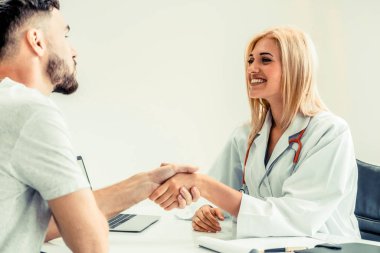 Kadın doktor hastane office odasında erkek hasta ile karşılıklı yapıyor. Sağlık ve Medikal hizmet meslekleri.