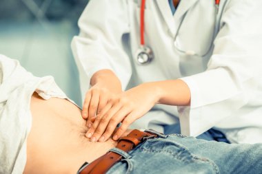Kadın doktor konuşuyor ve erkek hasta hastane ofisinde inceleyerek. Sağlık ve tıbbi hizmet.