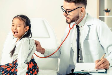 Genç erkek doktor hastane Office küçük çocuk incelenmesi. Çocuk mutlu ve Doktor korkmuyorum. Tıbbi çocuk sağlık kavramı.