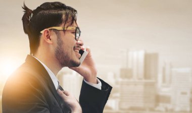 Gerçeküstü iletişim kavramı - genç işadamı istimal hareket eden telefon ile modern şehir binaları arka plan görüntüsü. Gelecek yenilik teknoloji ve Internet şey (çok ).