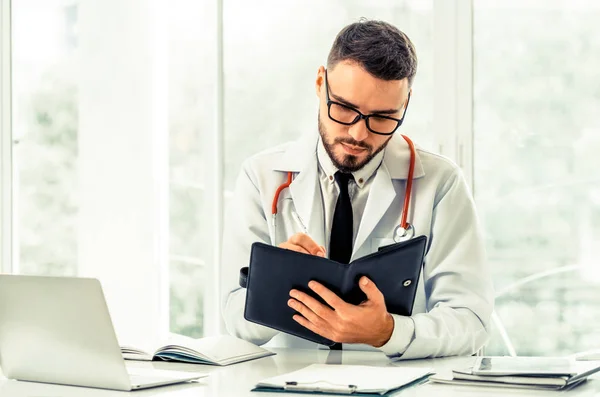 Doctor Leyendo Mientras Escribe Una Nota Libro Oficina Hospital Concepto —  Fotos de Stock
