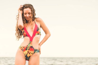 Tatil seyahat etmek tatil için yaz aylarında tropikal plaj keyfi yerinde mayo giyen mutlu genç kadın.