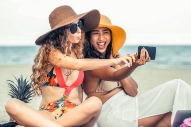 Mutlu kadın selfie fotoğraf birlikte cep telefonundan tropikal kum plaj yaz tatile içinde bikinis. Seyahat yaşam tarzı.