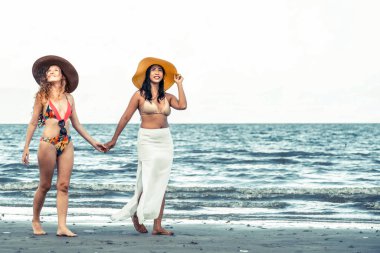 Bikinili mutlu kadın birlikte yaz tatil tropikal kum plaj güneşlenme gitmek. Seyahat yaşam tarzı.