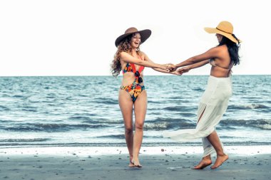 Bikinili mutlu kadın birlikte yaz tatil tropikal Kum Plajı üzerinde dans. Seyahat yaşam tarzı.