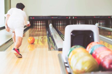 Genç adam bowling spor kulübünde oynarken.