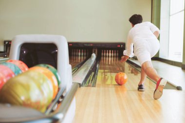 Genç adam bowling spor kulübünde oynarken.