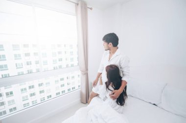 Mutlu genç çift rahatlatıcı sabah uyandıktan sonra eve yatak odasında.