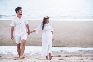 Mutlu genç çift balayı sırasında sahilde yürüyüş tatil seyahat.