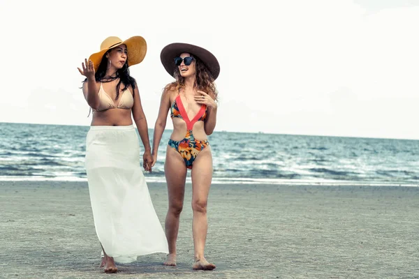 Bikinili mutlu kadın birlikte yaz tatil tropikal kum plaj güneşlenme gitmek. Seyahat yaşam tarzı.