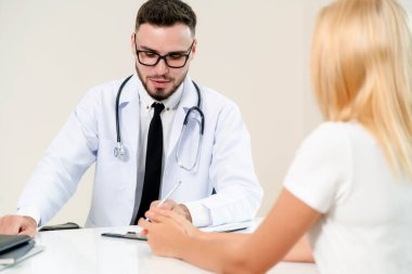 Erkek doktor hastane ofiste bayan hasta konuşuyor. Sağlık ve tıbbi hizmet.