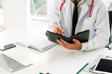 Doktor ofisinde hastanede bir kitap üzerine not yazarken okuma. Tıbbi ve sağlık kavramı.