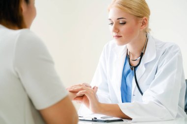 Kadın doktor hastane ofiste bayan hasta için eller tarafından hasta darbe incelenirken konuşuyor. Sağlık ve tıbbi hizmet.