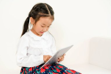 Tablet bilgisayar ile beyaz arka plan üzerinde küçük mutlu çocuk. Çocukluk yaşam tarzı.