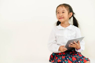 Tablet bilgisayar ile beyaz arka plan üzerinde küçük mutlu çocuk. Çocukluk yaşam tarzı.