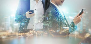 Cep telefonu ile modern şehir binaları arka plan kullanarak genç iş adamları. Gelecekteki telekomünikasyon teknolojisi ve internet şeyler (çok) kavramının.