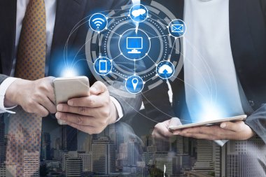 Cep telefonu ile modern şehir binaları arka plan kullanarak genç iş adamları. Gelecekteki telekomünikasyon teknolojisi ve internet şeyler (çok) kavramının.