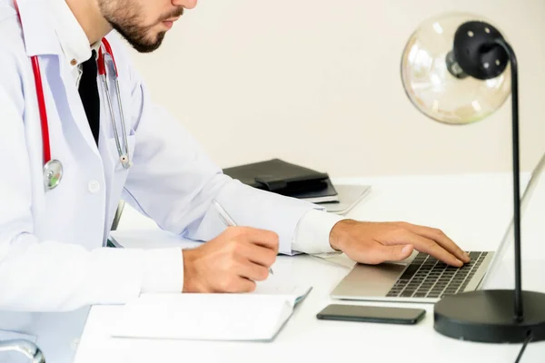 의사는 병원에서 사무실 테이블에 노트북 컴퓨터에서 — 스톡 사진