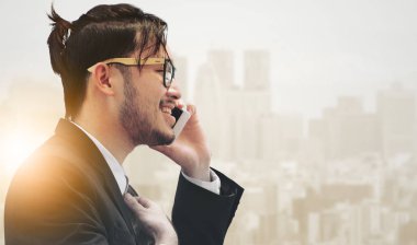 Gerçeküstü iletişim kavramı - genç işadamı istimal hareket eden telefon ile modern şehir binaları arka plan görüntüsü. Gelecek yenilik teknoloji ve Internet şey (çok ).