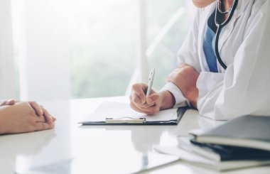 Kadın doktor görüşmeler yazarken bayan hasta için hastanın sağlık kaydının hastane ofiste. Sağlık ve tıbbi hizmet.