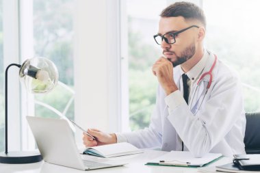 Doktor hastanede Ofis masaları, dizüstü bilgisayar üzerinde çalışıyor. Tıbbi ve sağlık kavramı.