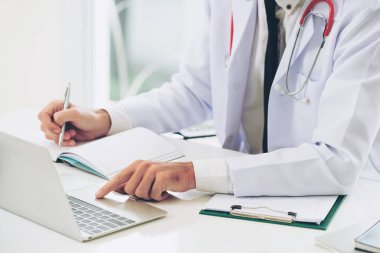 Doktor hastanede Ofis masaları, dizüstü bilgisayar üzerinde çalışıyor. Tıbbi ve sağlık kavramı.