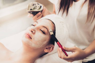 Güzeller güzeli kadın, sağlık merkezindeki profesyonel dermatologdan yüz temizleme tedavisi görüyor. Yaşlanma önleyici, yüz bakımı ve lüks yaşam tarzı konsepti.