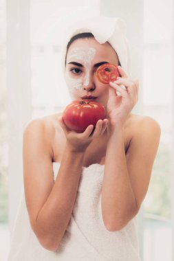 Bir yüz maskesi tedavi ile domates krem ayıklayabilirsiniz doğa tedavisinin yararı gösterilen sahip güzel bir kadın. Anti-aging kozmetik, yüz cilt bakımı ve lüks yaşam tarzı kavramı.
