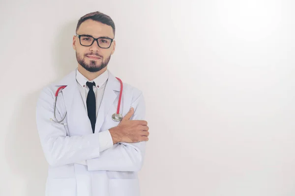 Joven Médico Guapo Con Los Brazos Cruzados Pie Sobre Fondo — Foto de Stock