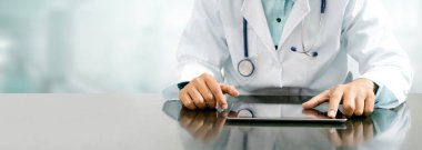 Tablet bilgisayar Hastanesi Office ile masada oturan erkek doktor. Tıbbi sağlık personeli ve doktor hizmeti.