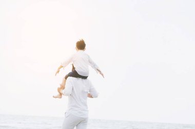 Mutlu baba oğlu yaz aylarında boyun tropikal bir kum Plajı üzerinde taşıyan.