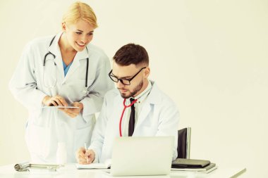 Doktor hastane ofis dizüstü bilgisayar masanın üzerinde başka bir doktor hasta sağlık hakkında tartışma ile çalışma.