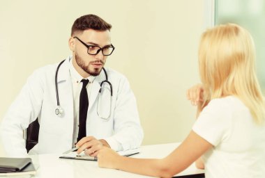 Erkek doktor hastane ofiste bayan hasta konuşuyor. Sağlık ve tıbbi hizmet.