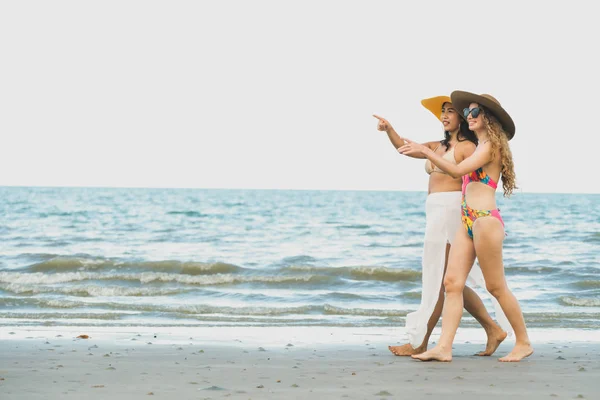 ビキニで幸せな女性は 夏休みで熱帯の砂浜に一緒に日光浴に行きます 旅行のライフ スタイル — ストック写真