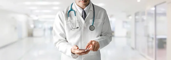 Άντρας Γιατρός Που Χρησιμοποιεί Κινητό Τηλέφωνο Στο Νοσοκομείο Ιατρική Περίθαλψη — Φωτογραφία Αρχείου
