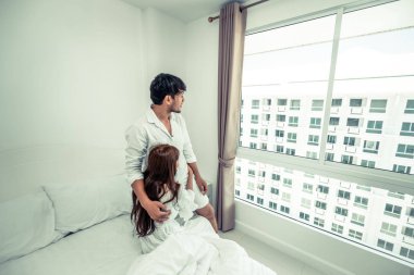 Mutlu genç çift rahatlatıcı sabah uyandıktan sonra eve yatak odasında.