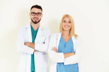 Kendine güvenen Gp doktor ve silah ile cerrahi doktor portre beyaz arka plan üzerinde çarpı işareti.