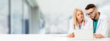 Doktor hastanede başka bir doktor ile bir tartışma yaparken ofiste dizüstü bilgisayarla çalışma. Tıbbi sağlık ve doktor hizmeti.