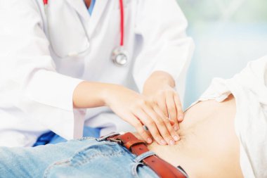 Kadın doktor konuşuyor ve erkek hasta hastane ofisinde inceleyerek. Sağlık ve tıbbi hizmet.